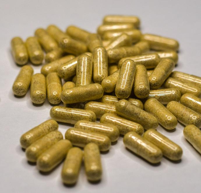a pile of yellow pills sitting on top of a table