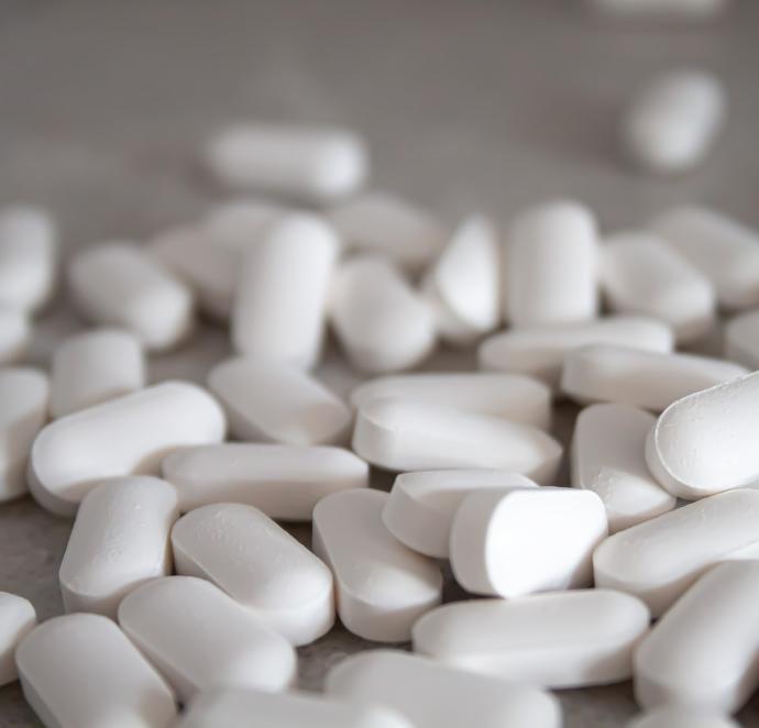 white medication pills on brown surface